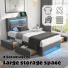 A gray upholstered bed with LED lighting and storage drawers, with icons representing clothing and storage. Produktbild-Vorschau