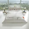 A bed with a heart-patterned duvet cover and pillows, set against a large window with a scenic view. Produktbild-Vorschau