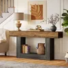 A console table with decorative items and books, placed in a hallway next to a staircase and armchair. Anteprima dell’immagine prodotto