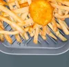 French fries and a chicken nugget in an air fryer basket. Produktbild-Vorschau
