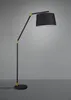 A modern black arc floor lamp with a fabric shade and gold accents, set against a plain gray background. Náhled obrázku produktu