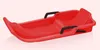 A red plastic sled with black handles is shown against a light gray and white background. Náhled obrázku produktu