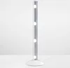 A silver LED light bar with four circular lights, standing on a white base, against a white background. Podgląd zdjęcia produktu