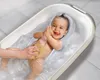 A baby is taking a bath in a baby bathtub, being washed by an adult's hand. Produktbild-Vorschau