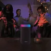 People dancing at a party with a speaker and candle on a table. Voir les images du produit