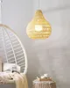 A hanging lamp made of woven material is shown in a room with a hanging chair and a small stool with cups. Podgląd zdjęcia produktu