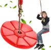A young boy is sitting on a red disc swing, which is hanging from a rope. Anteprima dell’immagine prodotto