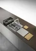 A modern kitchen countertop with a sink and various accessories laid out. Voir les images du produit