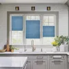 A kitchen sink area with blue blinds on the window above. Produktbild-Vorschau