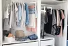 A well-organized closet with clothes neatly hung and folded. Anteprima dell’immagine prodotto