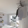 A bedroom scene with a ceiling-mounted clothes drying rack. Podgląd zdjęcia produktu