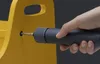 A hand is using a gray electric screwdriver to screw into a yellow object. Podgląd zdjęcia produktu