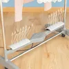Close-up of the base of a gray electric clothes drying rack with white perforated panels, showing arrows indicating airflow. Náhled obrázku produktu