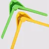 Two garlic presses, one green and one yellow, are displayed against a light gray background. Produktbild-Vorschau
