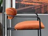 A close-up shot of an orange bar stool with a black metal frame. Náhľad obrázku produktu