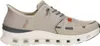 A side view of a single beige Skechers Glide Step Slip In sports shoe on a white background. Voir les images du produit