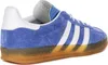 A side view of a blue Adidas Gazelle Indoor sneaker with white stripes and a gum sole. Produktbild-Vorschau