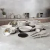 A collection of white cookware and kitchen utensils arranged on a countertop. Náhled obrázku produktu