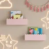 A child's bedroom wall decorated with pink cloud-shaped shelves, books, and star-shaped neon lights. Produktbild-Vorschau