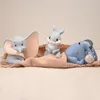 Three Disney character figurines (Dumbo, Thumper, and Eeyore) are arranged on a light brown fabric. Produktbild-Vorschau