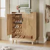 A wooden shoe cabinet with doors open, displaying various shoes on shelves. A handbag and flowers are on top of the cabinet. The cabinet is in a hallway or entryway setting. Podgląd zdjęcia produktu