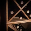 A close-up view of a wooden wine rack with several wine bottles stored inside. Voir les images du produit