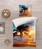 A bedding set with a tropical sunset scene is laid out on a wooden floor, with a pillow and a duvet cover visible. Decorative items like a woven basket and a small rug are placed nearby. Produktbild-Vorschau