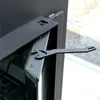A close-up view of a black metal hinge mechanism on a fireplace insert. Anteprima dell’immagine prodotto