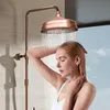 A woman is showering with a copper shower head. Produktbild-Vorschau