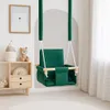 A green baby swing is hanging in a room with a shelf and a picture on the wall. Produktbild-Vorschau