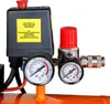 Close-up of an air compressor's pressure control unit with gauges and a warning label. Anteprima dell’immagine prodotto