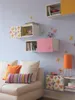 A decorated wall with shelves and a couch. Produktbild-Vorschau