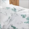 A close-up view of a white duvet cover with a green and gray floral pattern, laid out on a bed with a wooden headboard visible in the background. Produktbild-Vorschau