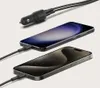 A black car charger with two cables plugged into two smartphones. Anteprima dell’immagine prodotto