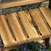 Close-up view of wooden planks on a shelf, with purple flowers in the foreground. Produktbild-Vorschau