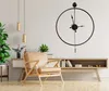 A modern living room with a large wall clock, a leather armchair, and a wooden media console. Voir les images du produit