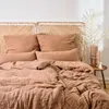 A neatly made bed with a woven headboard and textured bedding in a warm, earthy tone. Voir les images du produit