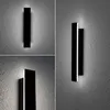 Collage of three images showing a modern black outdoor wall light mounted on a textured gray wall, with light emanating from the top and bottom. Náhľad obrázku produktu