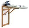 A wall-mounted ironing board with an iron and a folded shirt on it. Voir les images du produit