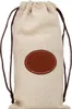 A beige drawstring pouch with a brown leather logo patch. Náhľad obrázku produktu