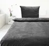 A bed with grey teddy bedding and a pillow. Produktbild-Vorschau