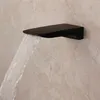 A black waterfall faucet mounted on a marble wall, with water flowing out. Náhled obrázku produktu