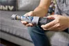 A person is holding a Dremel 7020 PGK electric nail grinder. Podgląd zdjęcia produktu
