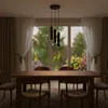 A dining room with a table and chairs, with a large window showing a garden view. Podgląd zdjęcia produktu