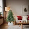 A living room decorated for Christmas with a tree, sofa, and coffee table. Podgląd zdjęcia produktu