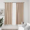 Two beige curtains hanging on a window rod, with a plant and a sofa visible in the background. Voir les images du produit