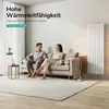 A couple relaxing on a sofa in a modern living room with a vertical radiator. Náhľad obrázku produktu