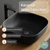 A black ceramic washbasin with a black faucet on a wooden countertop, with feature callouts. Produktbild-Vorschau