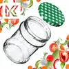 A glass jar and its lid are surrounded by various fresh vegetables and herbs, suggesting the contents or use of the jar for preserving food. Voir les images du produit