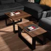 Two coffee tables with wooden tops and black metal frames are placed on a wooden floor in front of a dark gray sectional sofa. Náhled obrázku produktu